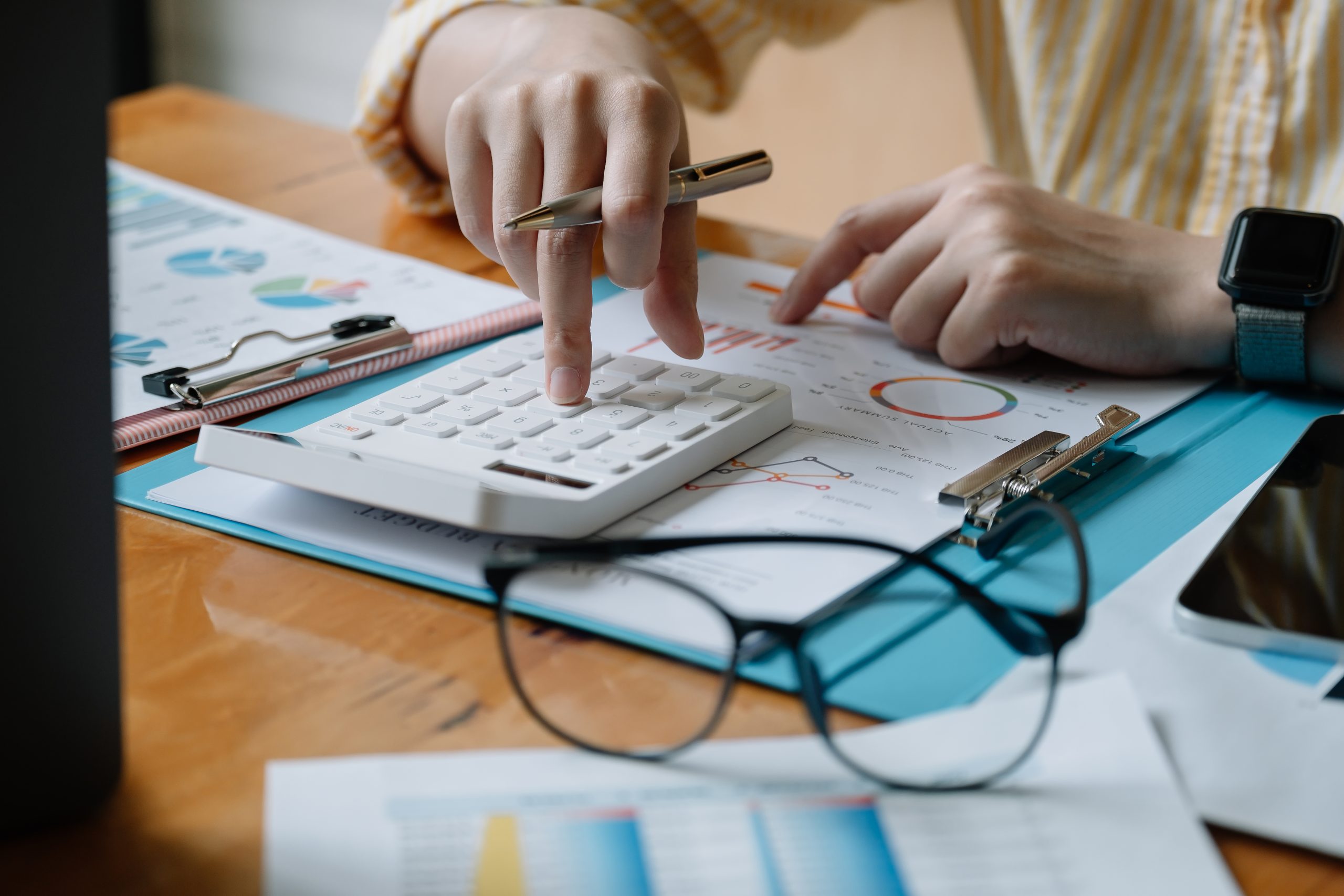 Accountant or banker calculate the financial report with calcula Accountant or banker calculate the financial report with calculator.